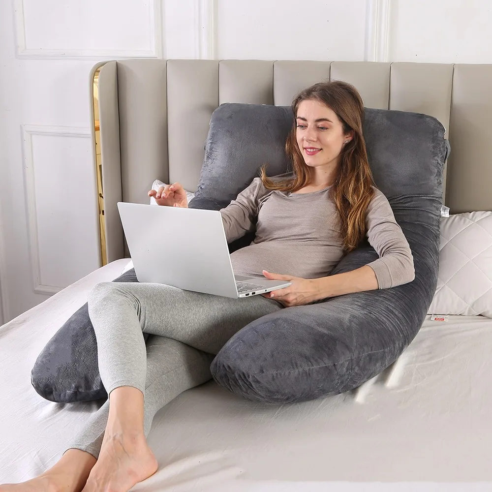 Almohada corporal en U de terciopelo Orlubi, gris, sobre una cama